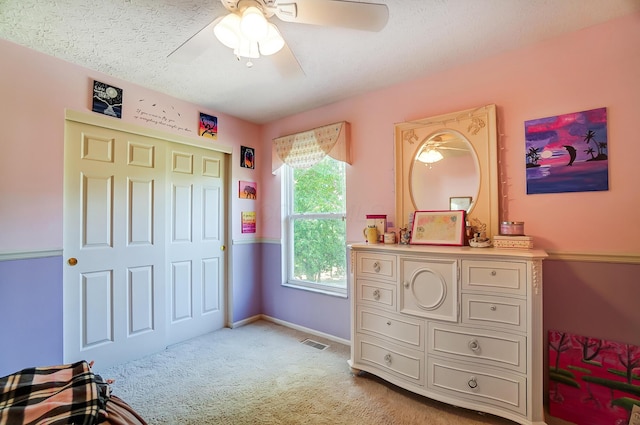 bedroom featuring visible vents, a ceiling fan, light carpet, a closet, and baseboards