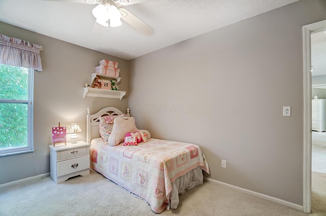 bedroom with a ceiling fan, baseboards, light colored carpet, and multiple windows