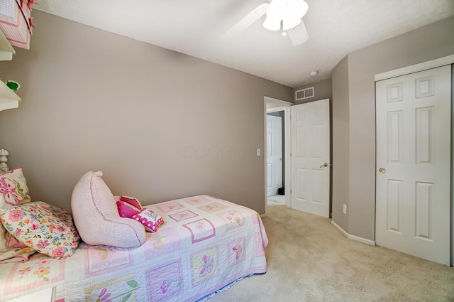 bedroom featuring visible vents, a ceiling fan, baseboards, and light carpet