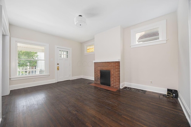 196 E Woodrow Ave, Columbus, OH 43207 - unfurnished living room featuring wood finished floors, baseboards, and a brick fireplace