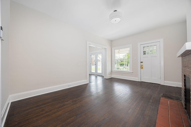 196 E Woodrow Ave, Columbus, OH 43207 - unfurnished living room featuring a brick fireplace, dark wood-style flooring, baseboards, and french doors
