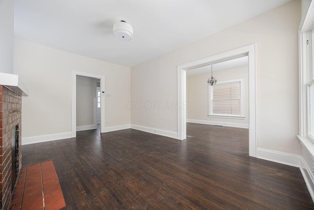 196 E Woodrow Ave, Columbus, OH 43207 - unfurnished living room featuring dark wood finished floors, a fireplace, and baseboards