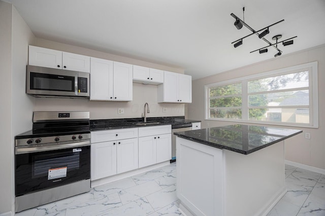196 E Woodrow Ave, Columbus, OH 43207 - kitchen with appliances with stainless steel finishes, light marble finish flooring, a sink, baseboards, and white cabinetry