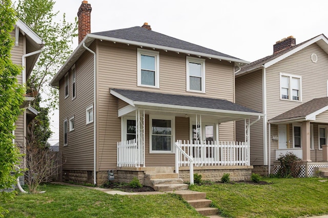 196 E Woodrow Ave, Columbus, OH 43207 - american foursquare style home with covered porch, a front lawn, and a chimney