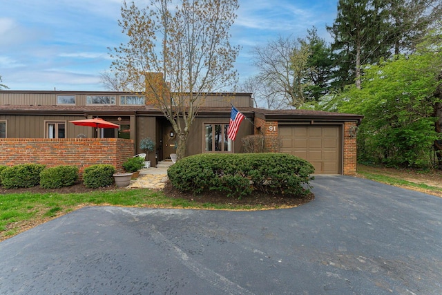 91 Glen Dr, Worthington, OH 43085 - mid-century modern home featuring brick siding, an attached garage, aphalt driveway, and fence