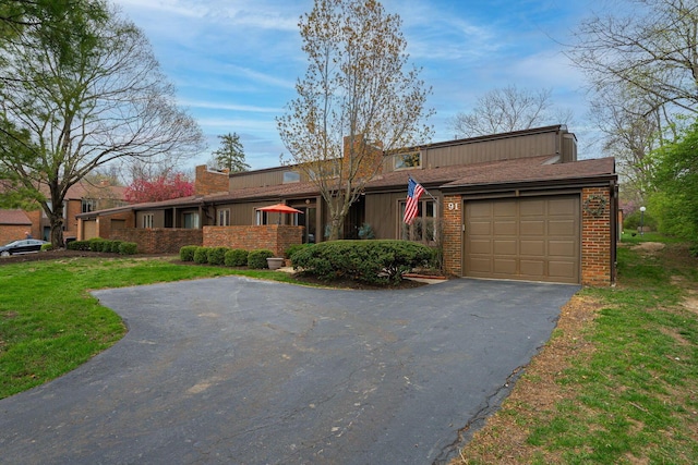 91 Glen Dr, Worthington, OH 43085 - view of front of house featuring a garage, brick siding, and aphalt driveway