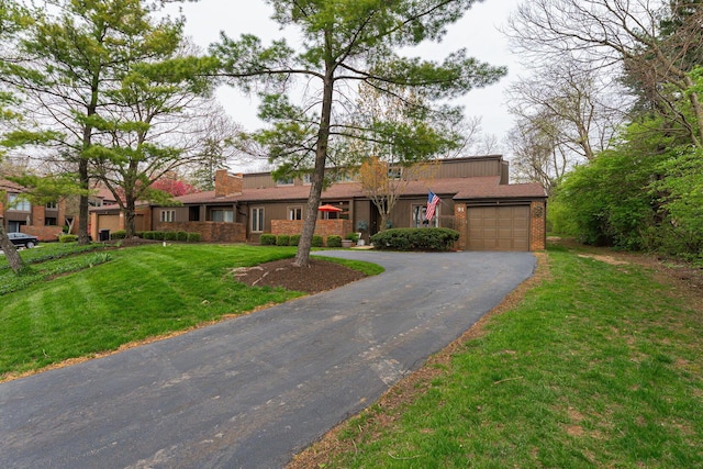 91 Glen Dr, Worthington, OH 43085 - ranch-style home with brick siding, an attached garage, a front lawn, and aphalt driveway