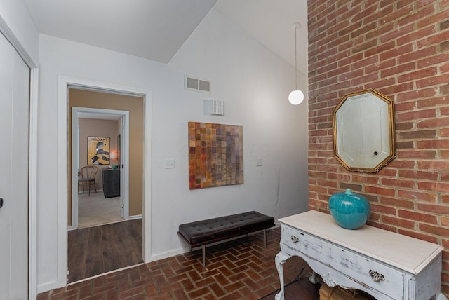 91 Glen Dr, Worthington, OH 43085 - corridor featuring brick floor, baseboards, visible vents, and vaulted ceiling