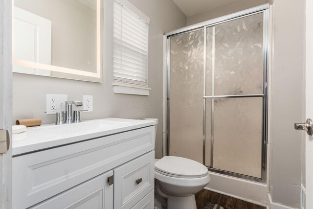 103 W Park Ave, Columbus, OH 43222 - bathroom with toilet, wood finished floors, vanity, and a stall shower