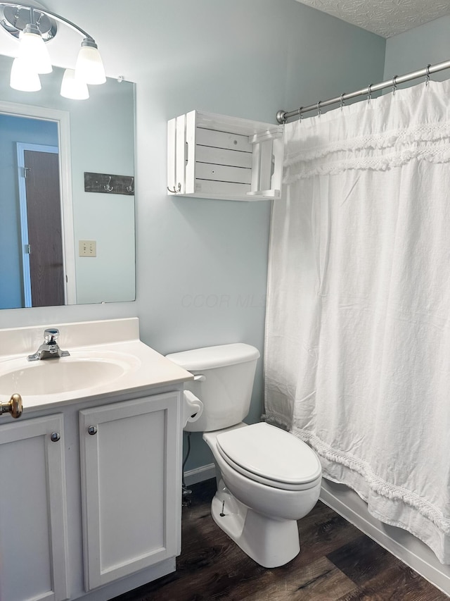 full bathroom featuring toilet, vanity, wood finished floors, and baseboards