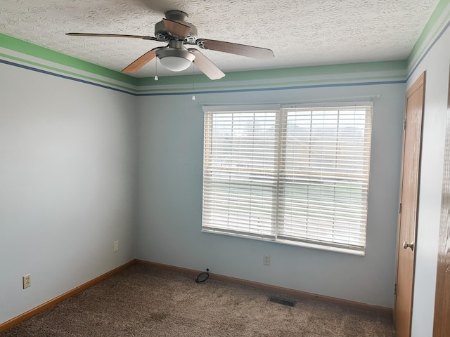 unfurnished room with a wealth of natural light, a ceiling fan, and carpet floors
