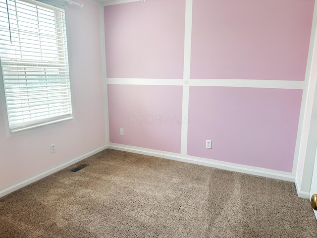 carpeted empty room with a wealth of natural light, visible vents, and baseboards