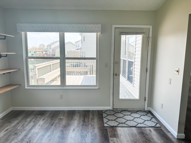 doorway to outside featuring wood finished floors and baseboards