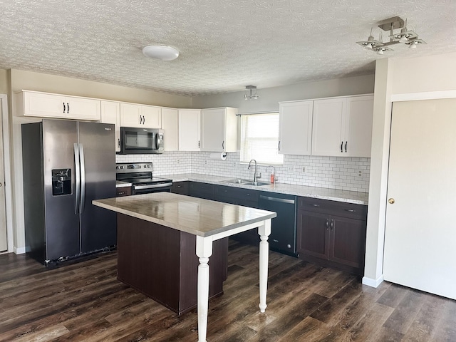 kitchen featuring stainless steel appliances, backsplash, white cabinets, and a sink