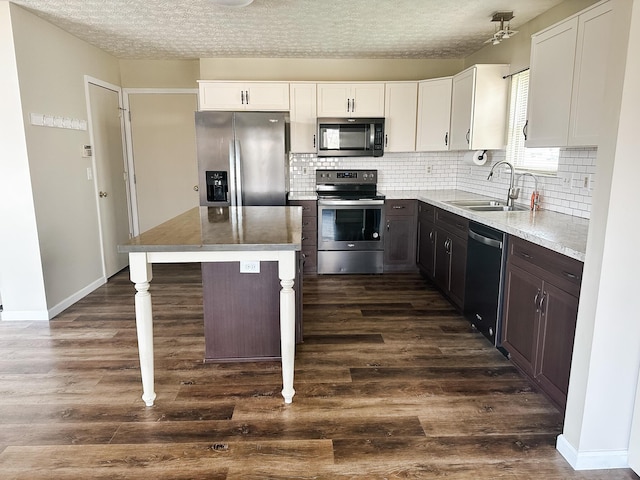 kitchen with dark wood-style floors, a sink, backsplash, and stainless steel appliances