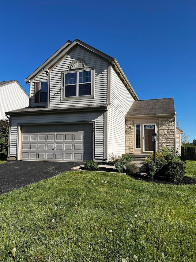 traditional home featuring a front lawn, stone siding, an attached garage, and aphalt driveway