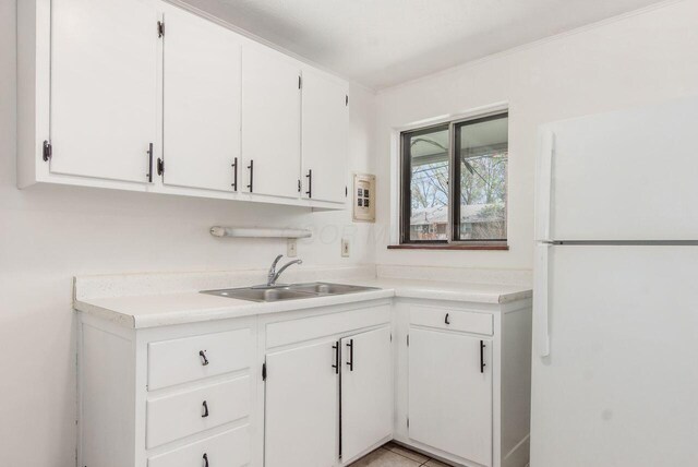 6350 Roselawn Ave, Reynoldsburg, OH 43068 - kitchen featuring white cabinets, freestanding refrigerator, light countertops, and a sink