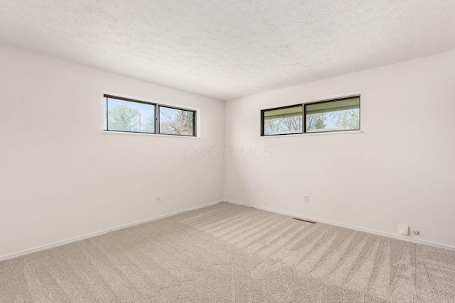 6350 Roselawn Ave, Reynoldsburg, OH 43068 - spare room featuring a textured ceiling, carpet floors, visible vents, and baseboards
