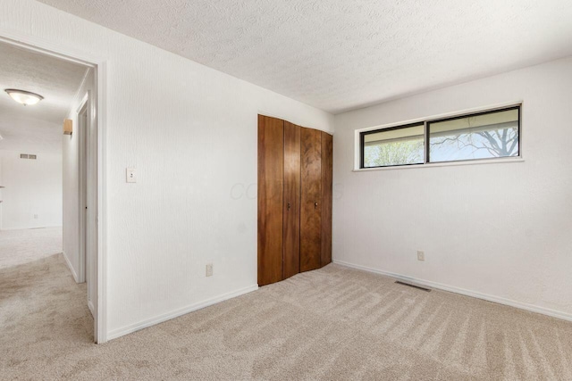 6350 Roselawn Ave, Reynoldsburg, OH 43068 - unfurnished bedroom featuring carpet flooring, a textured ceiling, visible vents, and a closet