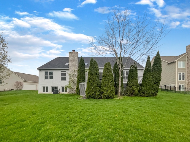 view of side of property featuring stucco siding, a yard, a chimney, and fence