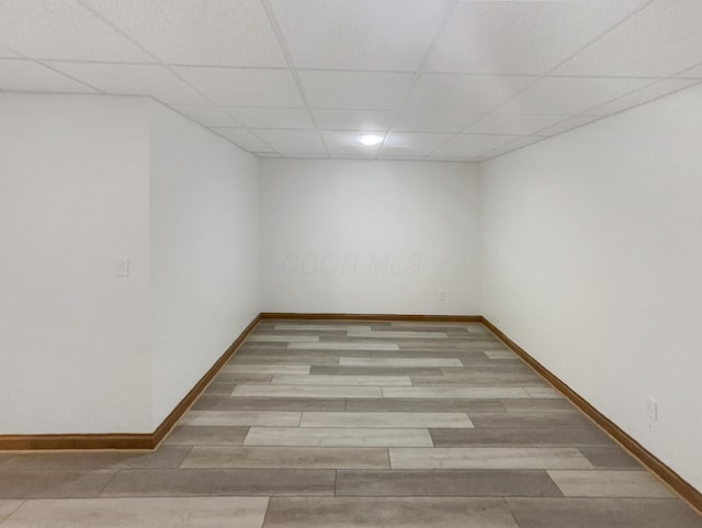 empty room featuring baseboards and a paneled ceiling