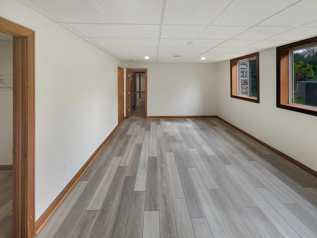 interior space featuring baseboards, wood finished floors, a drop ceiling, and recessed lighting
