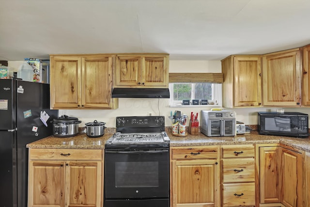 kitchen featuring light countertops, under cabinet range hood, a toaster, and black appliances