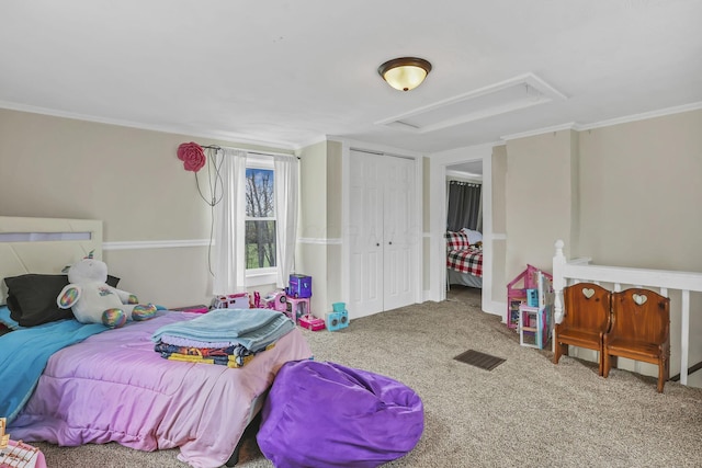 bedroom featuring attic access, carpet floors, ornamental molding, and a closet