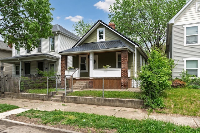 238 E Barthman Ave, Columbus, OH 43207 - view of front of property featuring a chimney, a porch, a fenced front yard, and brick siding