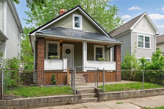 238 E Barthman Ave, Columbus, OH 43207 - bungalow-style house featuring a fenced front yard, a gate, a chimney, covered porch, and metal roof
