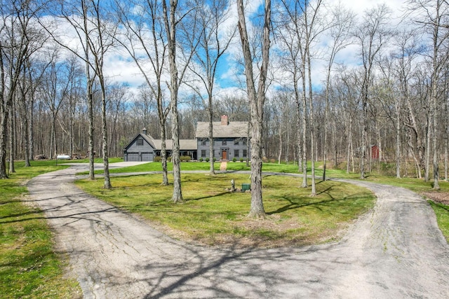 view of street featuring a wooded view and aphalt driveway