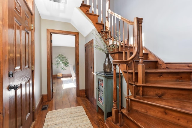 stairs with baseboards, visible vents, and wood-type flooring