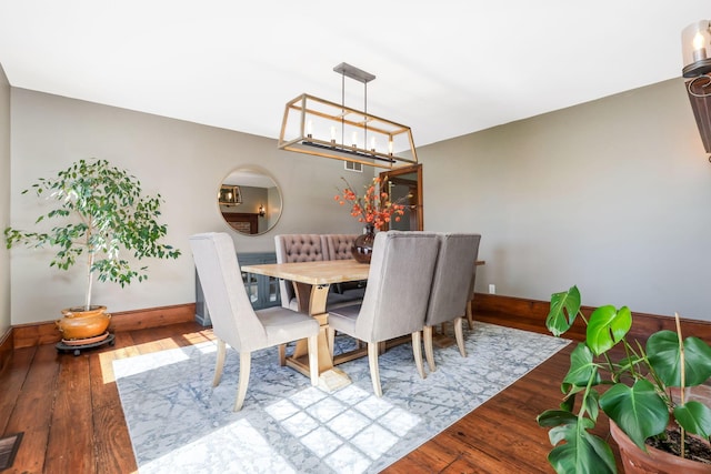 dining room with baseboards, a chandelier, and hardwood / wood-style floors