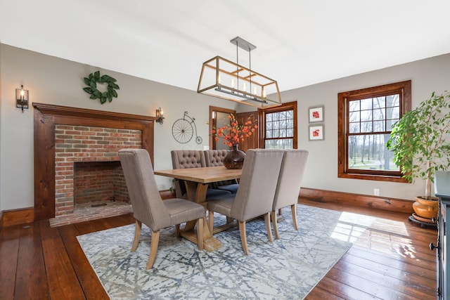 dining space with hardwood / wood-style floors and a fireplace