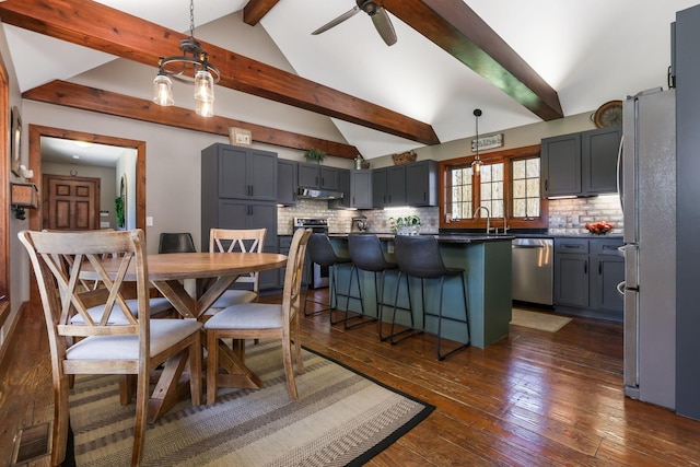 dining space with ceiling fan, dark wood-type flooring, vaulted ceiling with beams, and visible vents