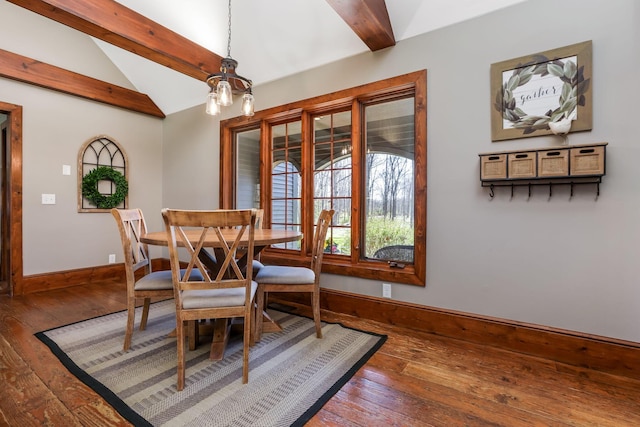 dining area featuring baseboards, vaulted ceiling with beams, hardwood / wood-style flooring, and an inviting chandelier