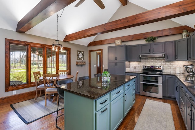 kitchen with range with two ovens, under cabinet range hood, vaulted ceiling with beams, and dark wood-style flooring