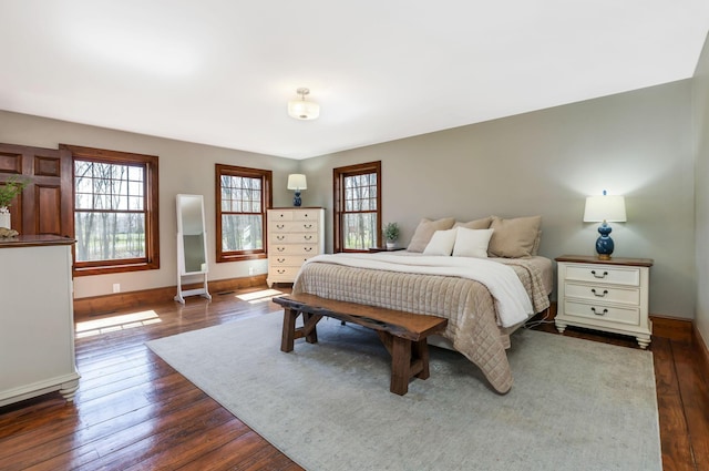 bedroom with baseboards and dark wood-style flooring