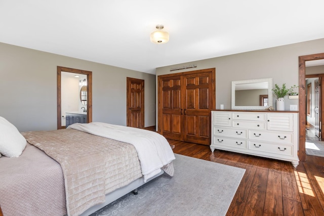 bedroom featuring radiator heating unit, a closet, dark wood-style flooring, and ensuite bathroom