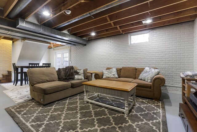 living area with finished concrete flooring and brick wall