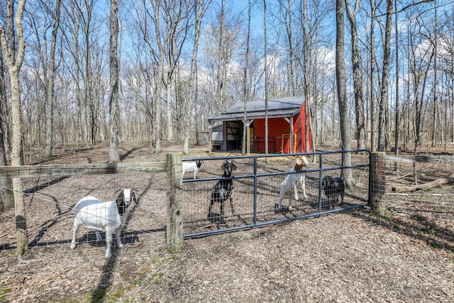 view of outdoor structure with fence, an outbuilding, and a gate