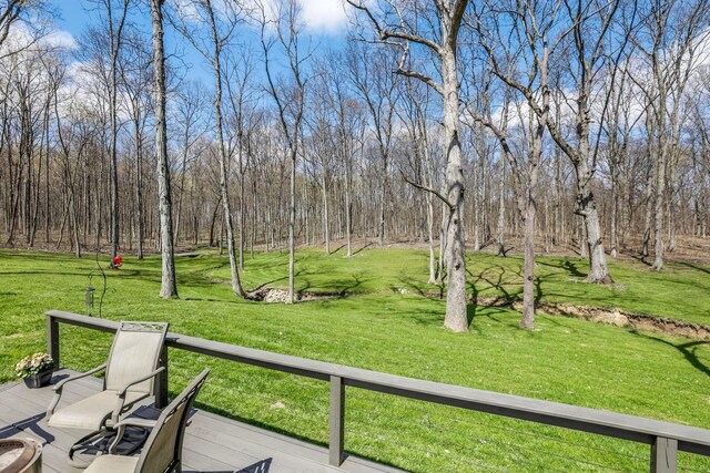 view of home's community with a wooden deck and a lawn
