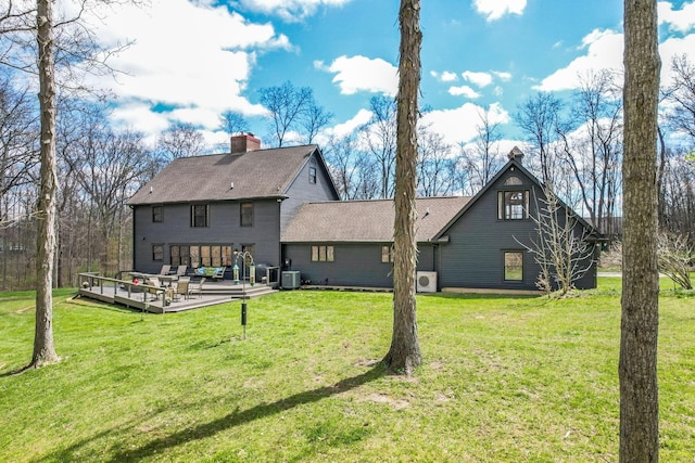 rear view of property with a lawn, central AC unit, and a deck