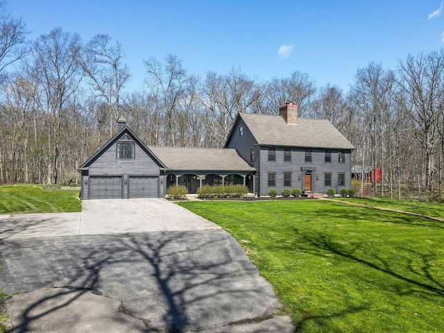 view of front facade with a chimney, driveway, and a front yard