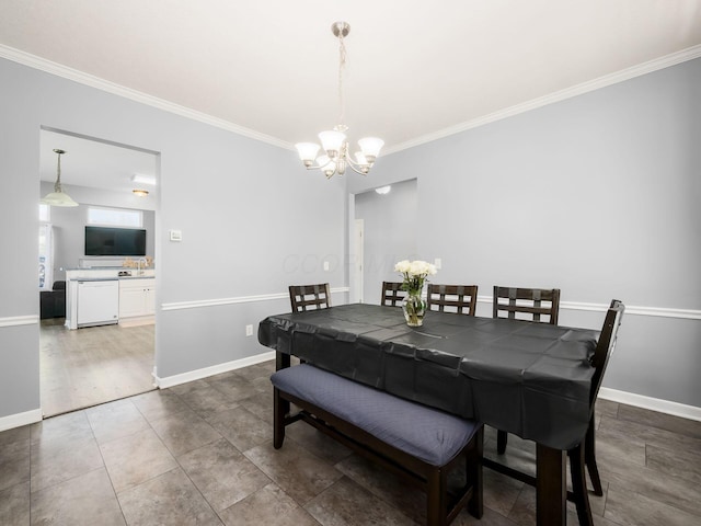 dining area featuring crown molding, baseboards, and an inviting chandelier
