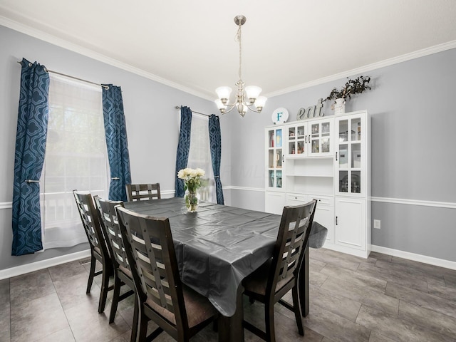 dining area with crown molding, baseboards, and a chandelier