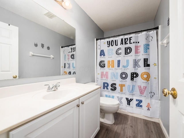 full bath with vanity, toilet, wood finished floors, and visible vents