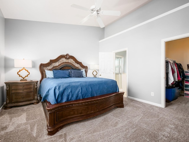 bedroom featuring a walk in closet, a ceiling fan, baseboards, a closet, and carpet flooring