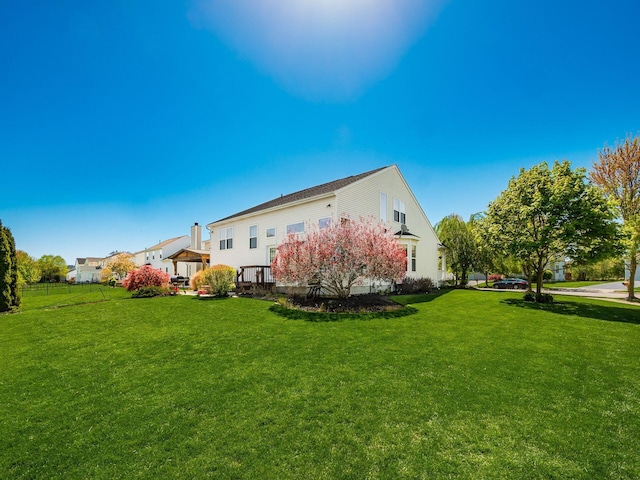 rear view of property featuring a lawn