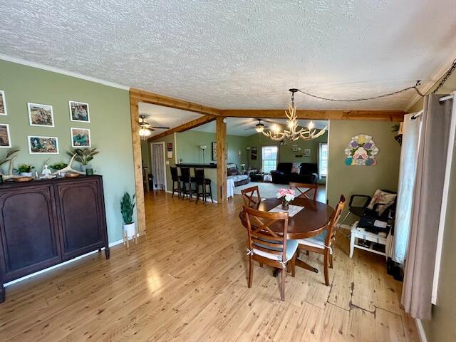9330 Pidcock Rd, Zanesville, OH 43701 - dining area with ornamental molding, a textured ceiling, light wood-type flooring, and ceiling fan with notable chandelier